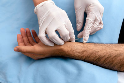 Midsection of doctor injecting acupuncture needle to patient