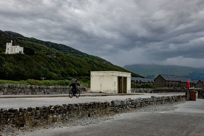 View of horse on road against cloudy sky