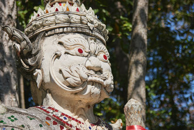 Close-up of buddha statue against trees