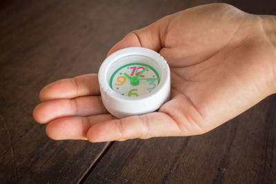 Close-up of hand holding toy clock