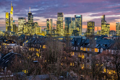 Illuminated cityscape against sky at dusk