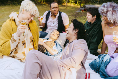 Happy friends from lgbtq community laughing together during dinner party in back yard