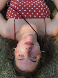 High angle portrait of young woman lying outdoors