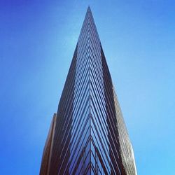 Low angle view of modern building against clear blue sky