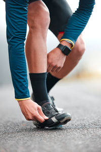 Low section of man walking on road