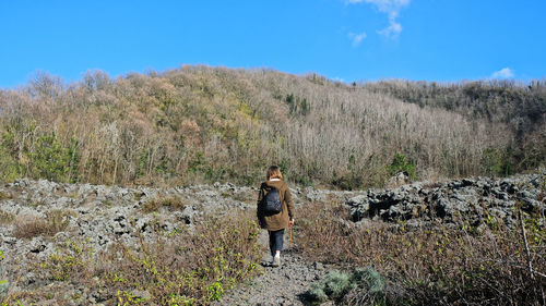 Woman standing on field against sky