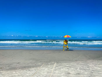 Full length of man on beach against blue sky