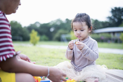 Side view of boy blowing bubbles while sitting at home