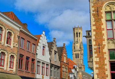 Low angle view of buildings against cloudy sky