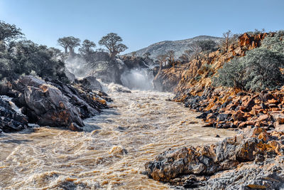 Scenic view of waterfall against clear sky