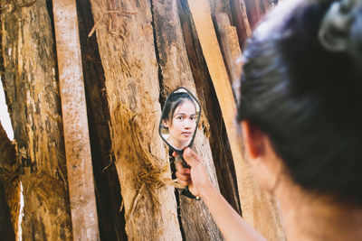 Portrait of young man against tree trunk