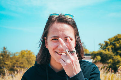 Portrait of man holding plant against sky