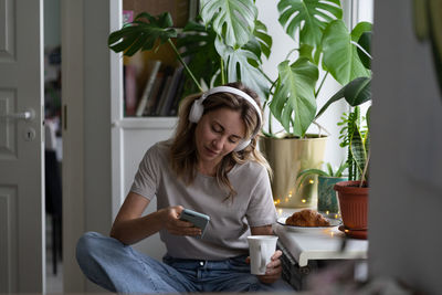 Young woman using phone while sitting in restaurant