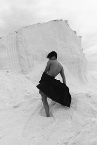 Rear view of woman standing on snow covered landscape