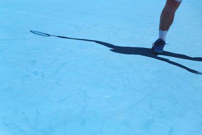 Low section of man standing on blue floor