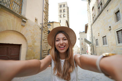 Self portrait of beautiful tourist girl in the historic town of arezzo, tuscany, italy