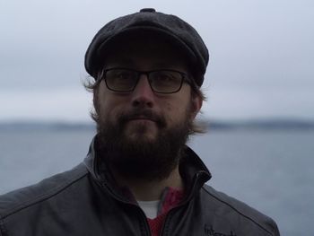 Portrait of young man wearing sunglasses against sea