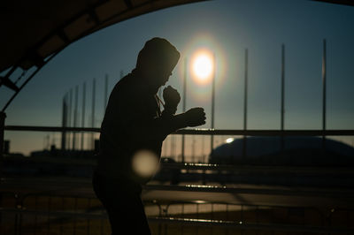 Low section of woman doing yoga at sunset