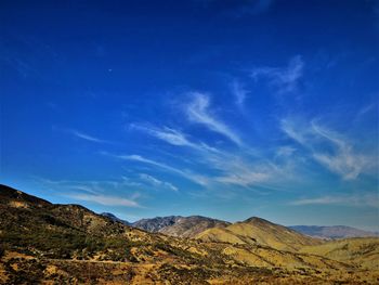 Scenic view of mountains against blue sky