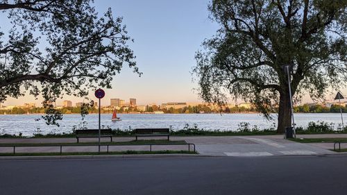 Road by river in city against sky