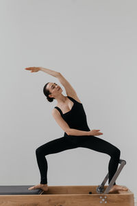 Low angle view of woman exercising against clear sky