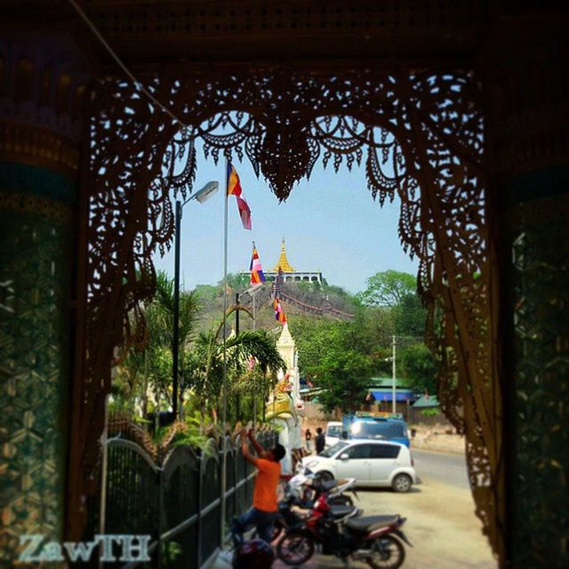 land vehicle, architecture, car, built structure, transportation, building exterior, tree, mode of transport, street, incidental people, road, travel, city, arch, sky, clear sky, day, travel destinations, outdoors