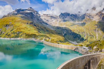 Scenic view of lake by mountains against sky