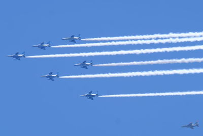 Low angle view of airplane flying against blue sky