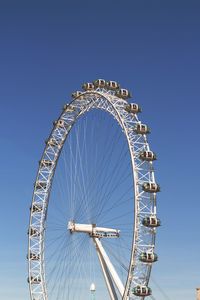 Low angle view of the london eye against blue sky