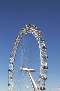 Low angle view of ferris wheel against blue sky