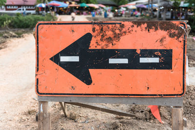 Close-up of arrow sign on road