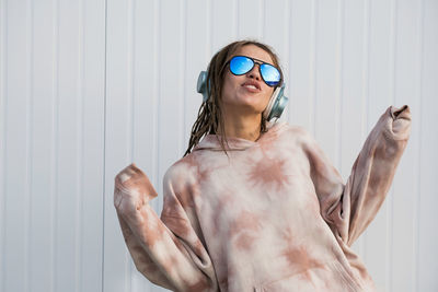 Dreadlock woman listening to music in headphones.