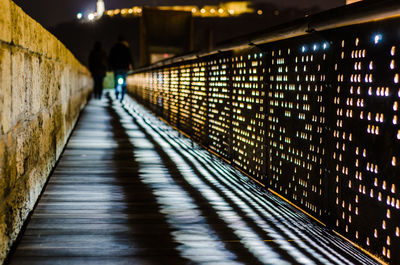 People walking on illuminated street at night