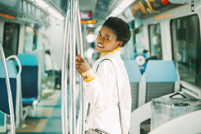 Side view of a smiling young woman in train