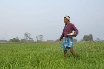 Full length of man standing on field against sky