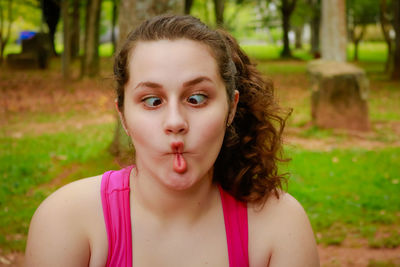 Close-up of funny teenage girl making face at park