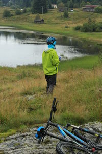 Rear view of woman standing on lakeshore