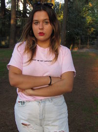Portrait of beautiful young woman standing on field