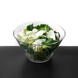 Close-up of chopped vegetables in bowl on table against white background