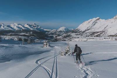 An unrecognizable male hiker wearing snowshoes running in the french alps on a cold winter day