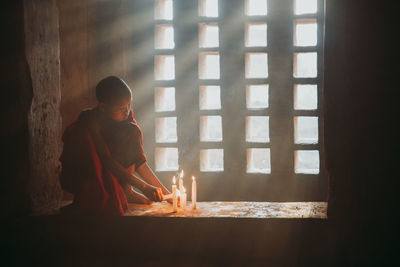 Boy looking through window at home