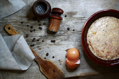 High angle view of food and broken egg on wooden table