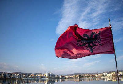 Red flag against blue sky in city