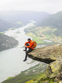 Hiker sitting on rock and looking at view
