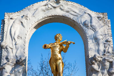 Low angle view of angel statue against blue sky