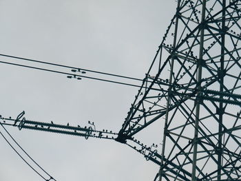 Low angle view of electricity pylon against sky