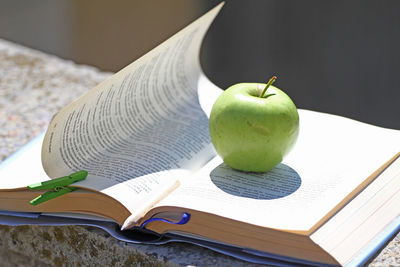 Close-up of apple and book on table