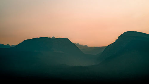 Scenic view of silhouette mountains against sky during sunset