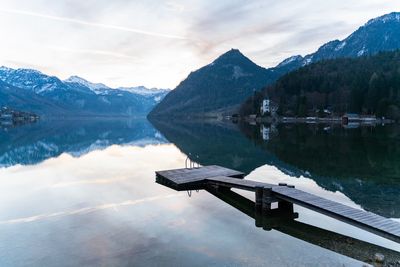 Scenic view of lake by snowcapped mountains against sky