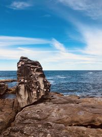 Rock formation on beach against sky